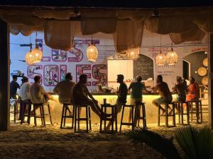 a group of people sitting at a bar at Lõst Soles Lodge in Jambiani