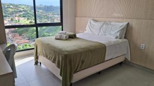 a bedroom with a bed with a teddy bear on it at Flat 205 Zuppolini in Bananeiras