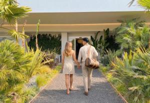 a man and woman walking into a house at Perla Verde Hotel in Milano Marittima