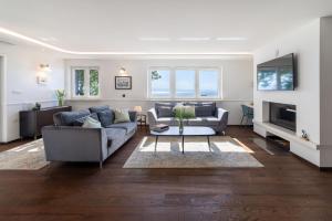 a living room with two couches and a tv at Villa Alba Moscenicka Draga in Mošćenice