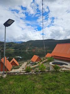 a sign in the grass next to a building at Alpine Lake Lodge Hotel in Cajamarca