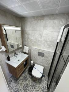 a bathroom with a sink and a toilet and a mirror at Lokal Ayvalık Guest House in Ayvalık