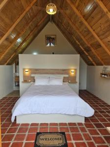 a large white bed in a room with a wooden ceiling at Alpine Lake Lodge Hotel in Cajamarca