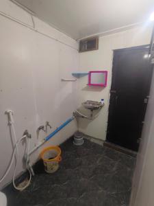 a bathroom with a sink and a black door at Linga Wooden Room Second floor in Kanchipuram