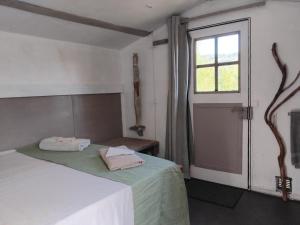 a bedroom with a bed with two towels on it at Cabane sous les oliviers in Saint-Ambroix