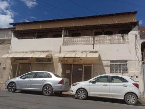 two cars parked in front of a building at Quarto 02 in Montes Claros