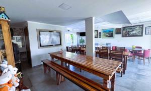 a dining room and living room with a wooden table at Pousada Castelo do Rei in Penha +66 photos