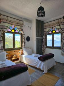 a bedroom with two beds and stained glass windows at Haven Hills Chaouen in Chefchaouen