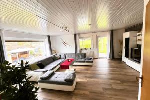 a living room with a couch and a table at Die Panorama-Wohnung-im-Grünem in Allensbach
