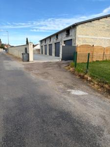an empty street next to a building with a fence at Studio, atypique in Chaufour-lès-Bonnières +5 photos