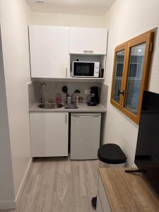a small kitchen with a sink and a microwave at Studio, atypique in Chaufour-lès-Bonnières
