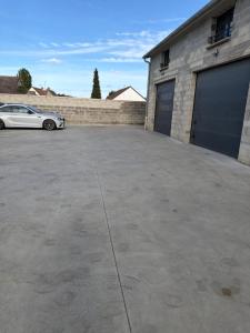 a car parked in a parking lot next to a garage at Studio, atypique in Chaufour-lès-Bonnières