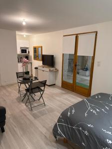 a bedroom with a bed and a table and a kitchen at Studio, atypique in Chaufour-lès-Bonnières