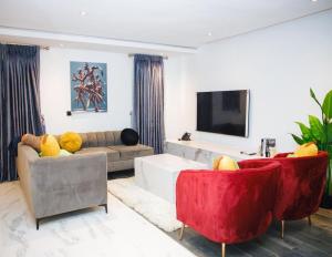 a living room with a couch and a tv at Billionaire Apartment in Lekki