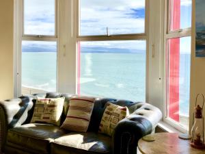 a leather couch in a room with a large window at The View in Criccieth