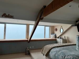 a bedroom with a bed and a large window at The View in Criccieth