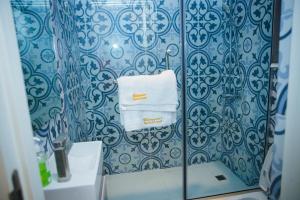 a bathroom with blue and white wallpaper and towels at Billionaire Apartment in Lekki