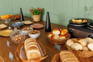 a table topped with baskets of bread and pastries at Solar Flat Hotel in Juiz de Fora