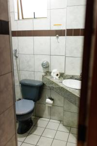 a bathroom with a blue toilet and a sink at Solar Flat Hotel in Juiz de Fora