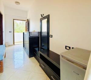 a kitchen with a black counter and a refrigerator at Santa Maria Dahab Hotel in Dahab