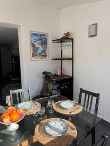 a dining room table with plates and bowls of fruit on it at villa rêve in Calvi