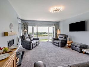 a living room with two chairs and a flat screen tv at 3 Bed in Dumfries oc-96066 in Dumfries
