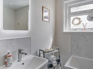 a white bathroom with a sink and a window at 3 Bed in Dumfries oc-96066 in Dumfries +24 photos