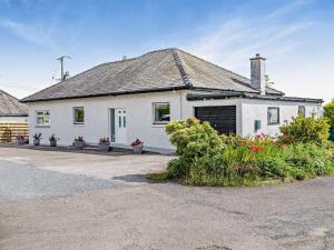 a white house with plants in front of it at 3 Bed in Dumfries oc-96066 in Dumfries