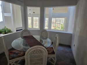 a dining room with a glass table and chairs at Casa Horizonte Azul Acapulco in Acapulco