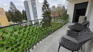 a balcony with two chairs and a table on it at Apartment Real in Bugojno