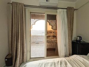 a bedroom with a bed and a large window at Zaytun Hotel Dahab in Dahab