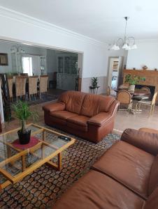 a living room with a leather couch and a table at Trégouët 8 - Chambre 2 in Saint-Nazaire