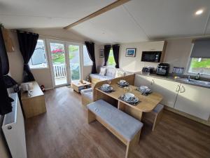 a living room with a dining table and a kitchen at Seaside View Caravan in Polperro in Looe