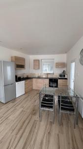 a kitchen with a glass table and a refrigerator at rozormant in Rosporden