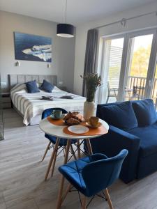 a living room with a blue couch and a table at Flauta Apartamenty in Augustów