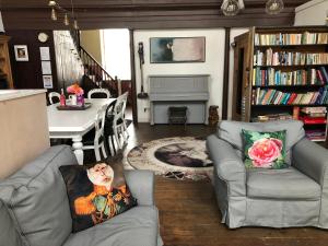 a living room with two chairs and a table at Creative Norfolk Chapel with Piano and Sauna Sleeps 10 in Briston