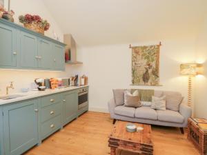 a living room with a couch and a table at The Little Loft in Burford