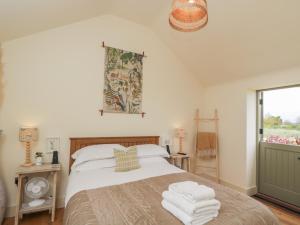a bedroom with a bed with towels on it at The Little Loft in Burford