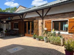 a brick house with a patio with potted plants at La maisonnette in Warmeriville