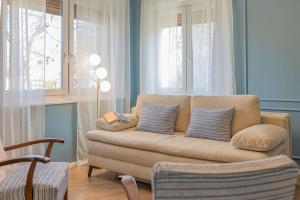 a living room with a couch and two windows at Ágnes Villa Balatonföldvár in Balatonföldvár +50 photos