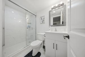 a white bathroom with a toilet and a shower at Caledon Quiet Luxury Escape 3BR Suite in Brampton +12 photos