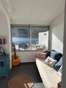 a living room with a couch and a guitar at villa rêve in Calvi