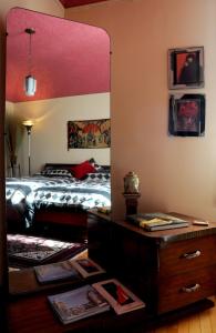 1 dormitorio con cama, espejo y tocador en Aux Années Folles, en Quebec