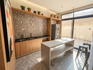 a kitchen with a white table and a counter at Upper West Perdizes by Xtay - Nubank Parque a 500m - antigo Allianz Parque - estúdio moderno com cozinha e vista da cidade in São Paulo +30 photos