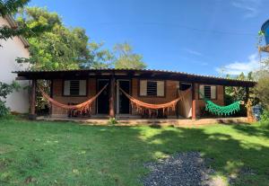 a house with a porch with drapes at Casa Studio Uirá em Chapada dos Guimarães in Chapada dos Guimarães