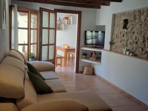 a living room with a couch and a television at Casa Alacantí in Pollença