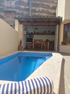 a large swimming pool in a room with a house at Casa Alacantí in Pollença