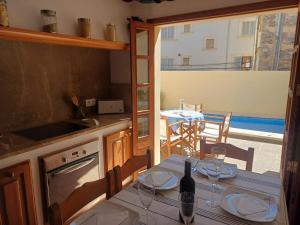 a kitchen with a table with a bottle of wine on it at Casa Alacantí in Pollença