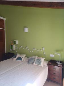 a bedroom with a white bed and a green wall at Casa Alacantí in Pollença +14 photos