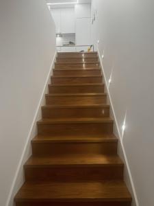 a staircase with wooden floors and white walls at Casa de Saudade - Refúgio junto ao mar in Paço de Arcos